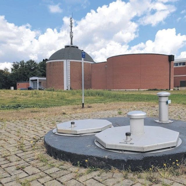 Das Foto zeigt einen abgedeckten Brunnenschacht vor den Gebäuden des Wasserwerks in Efferen.
