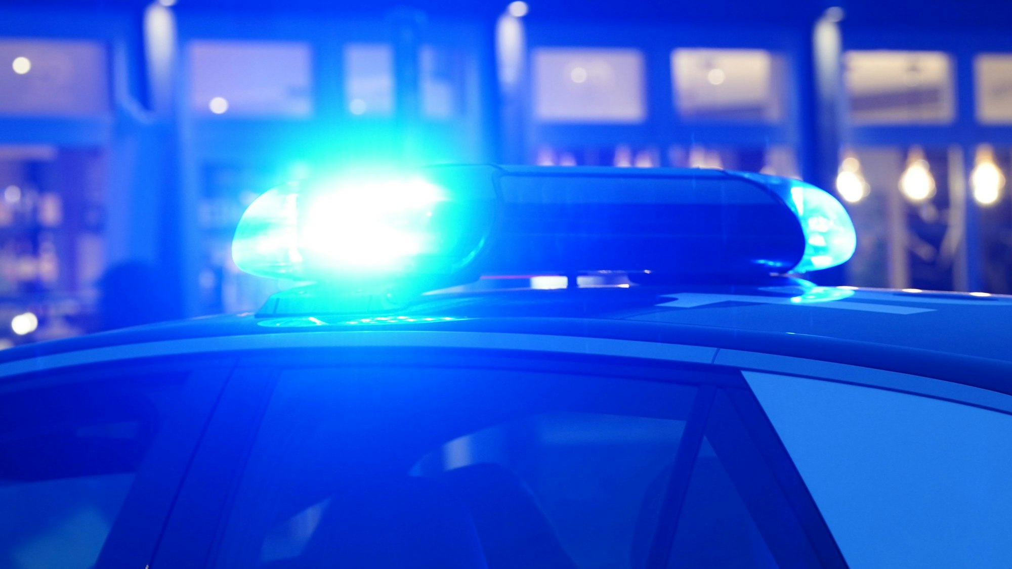 Ein Streifenwagen der Polizei steht mit eingeschaltetem Blaulicht an einem Einsatzort (Symbolfoto).