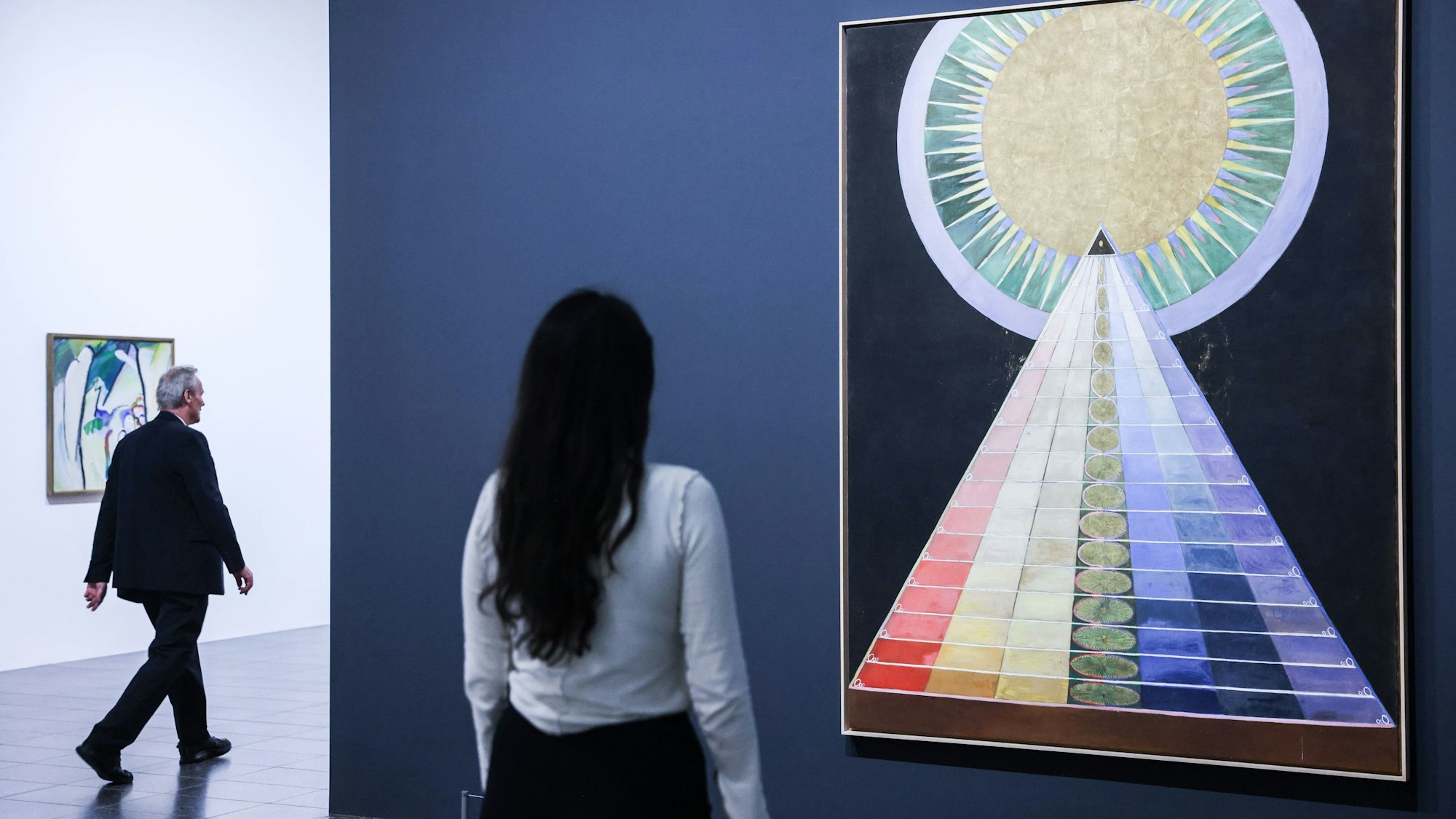 Eine Ausstellungsbesucherin betrachtet das Gemälde ·Altarbild· von Hilma af Klint.