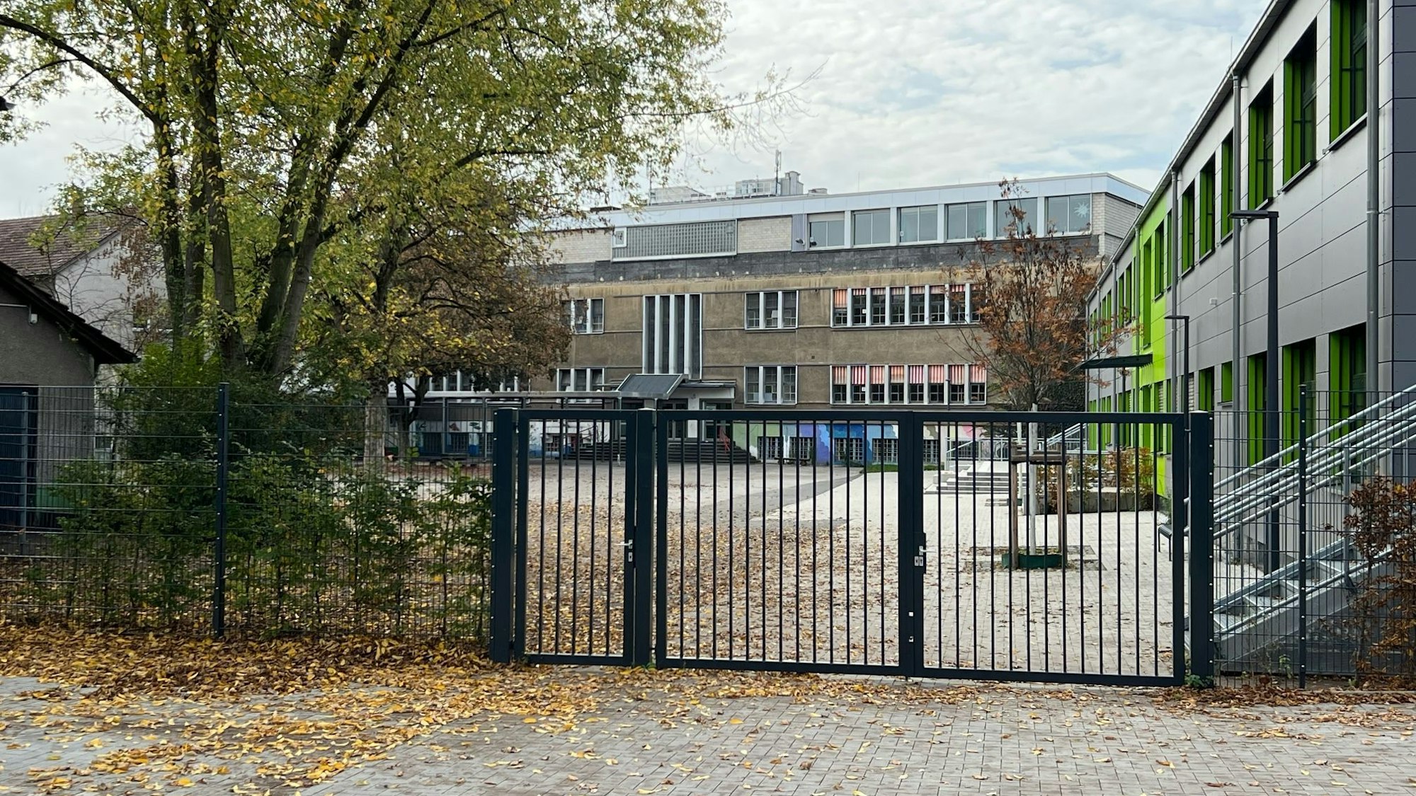Zu sehen ist der Schulhof der Gemeinschaftsgrundschule Porz-Mitte und Schulgebäude.