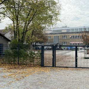 Zu sehen ist der Schulhof der Gemeinschaftsgrundschule Porz-Mitte und Schulgebäude.