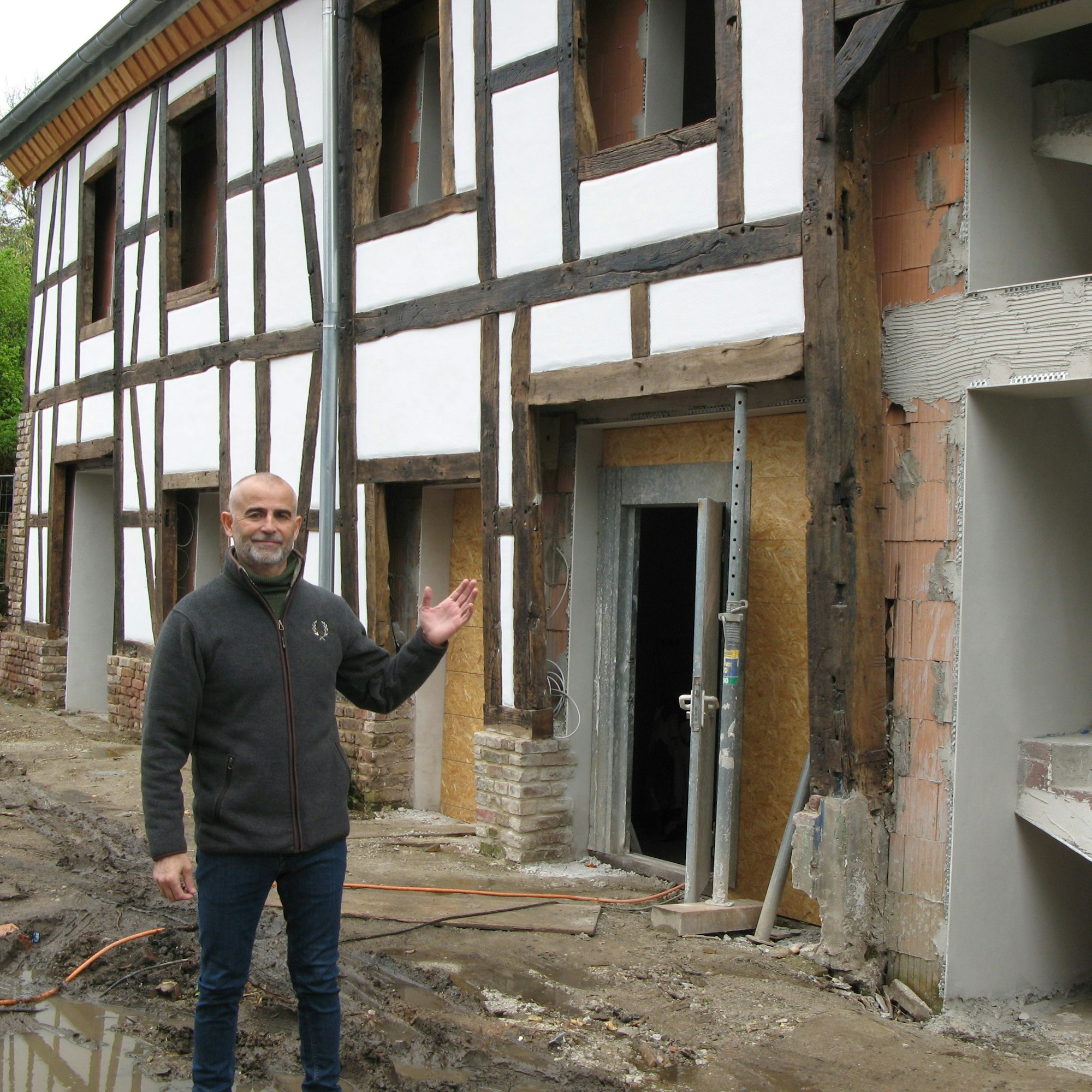 Der Bauunternehmer Mustafa Kaya, 57, steht vor zum Teil restaurierten Fachwerkscheune des Sternenhofs.