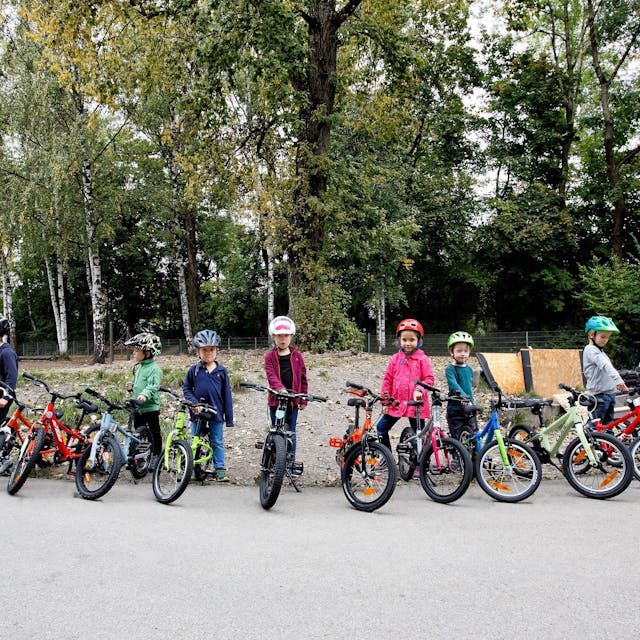 Viele Kinder stehen mit Fahrrädern in einer Reihe