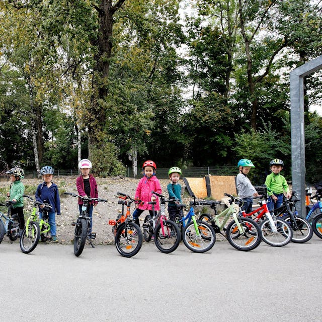 Viele Kinder stehen mit Fahrrädern in einer Reihe