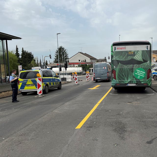 Ein Bus steht mit Unfallmarkierungen auf der Paffrather Stra0e in Bergisch Gladbach. Daneben stehen Polizeifahrzeuge.