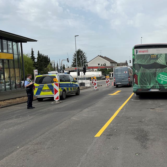 Ein Bus steht mit Unfallmarkierungen auf der Paffrather Stra0e in Bergisch Gladbach. Daneben stehen Polizeifahrzeuge.