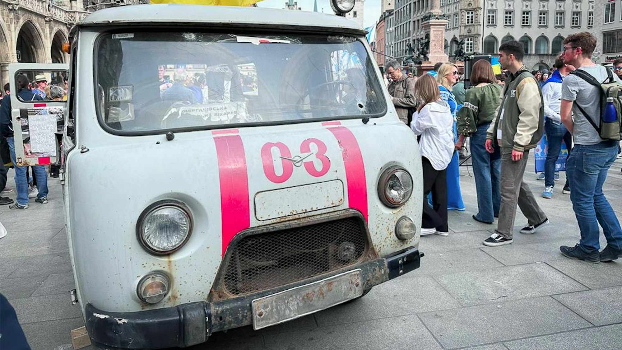 Ein beschossener ukrainischer Krankenwagen wird von Besuchern besichtigt.