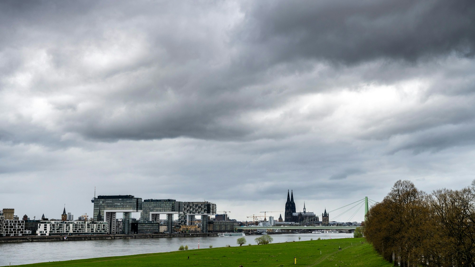 Kranhäuser und Dom vom rechten Rheinufer aus gesehen: Der Himmel über Köln ist mit dunklen Regenwolken verhangen (Bild vom 2. April).