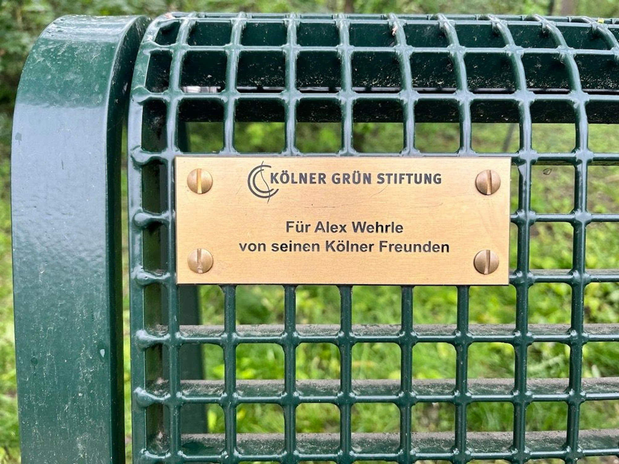 Schild an einer Bank am Geißbockheim mit der Aufschrift „Für Alexander Wehrle von seinen Kölner Freunden.“