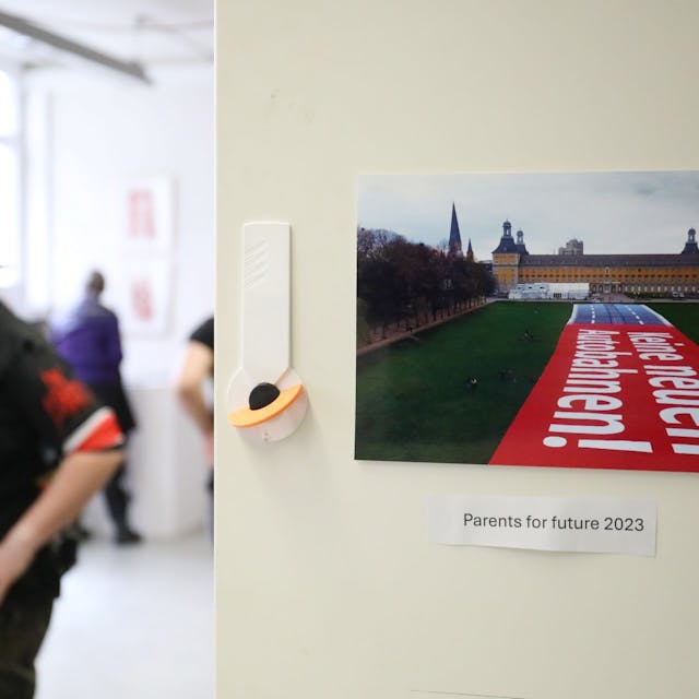 Ein Besucher in der Ausstellung neben einem Foto, das den Bonner Hofgarten und die Universität zeigt.