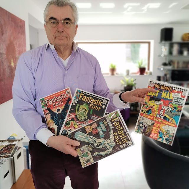 Zu sehen ist Werner Steinheimer, der Comics in der Hand hält.