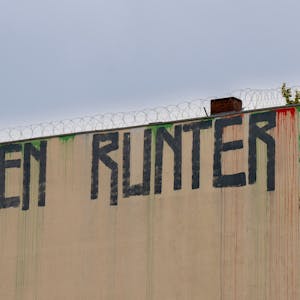 Berlin: Der Schriftzug „Mieten runter“ ist an der Wand eines Miethauses mit Graffiti beschmiert.