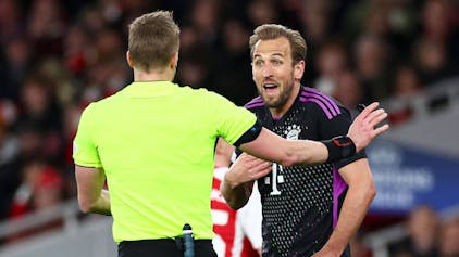 Schiedsrichter Glenn Nyberg und Bayern-Star Harry Kane diskutieren auf dem Spielfeld.