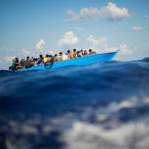 Migranten sitzen in einem Boot auf dem Meer.&nbsp;