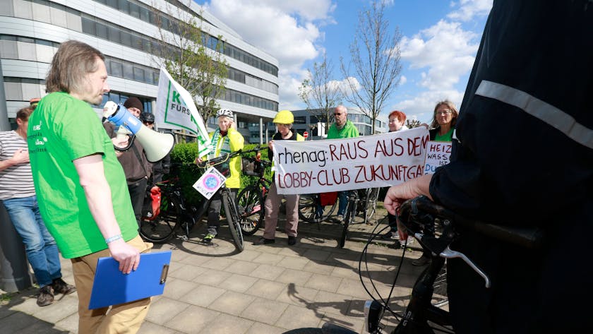 Demonstranten mit Fahrrädern stehen auf einer Straße. Auf einem Transparent steht: „Rhenag: Raus aus dem Lobby-Club Zukunft Gas“