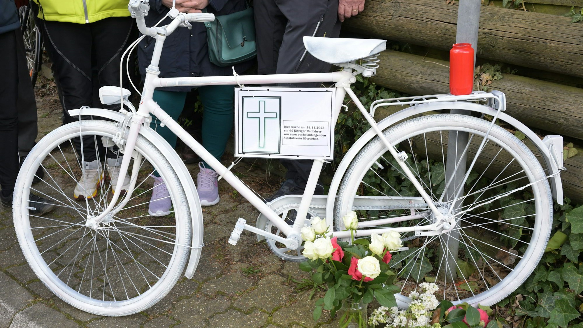 Ein weiß lackierte Fahrrad mit einem Zettel, darauf die Daten des Verunglückten.