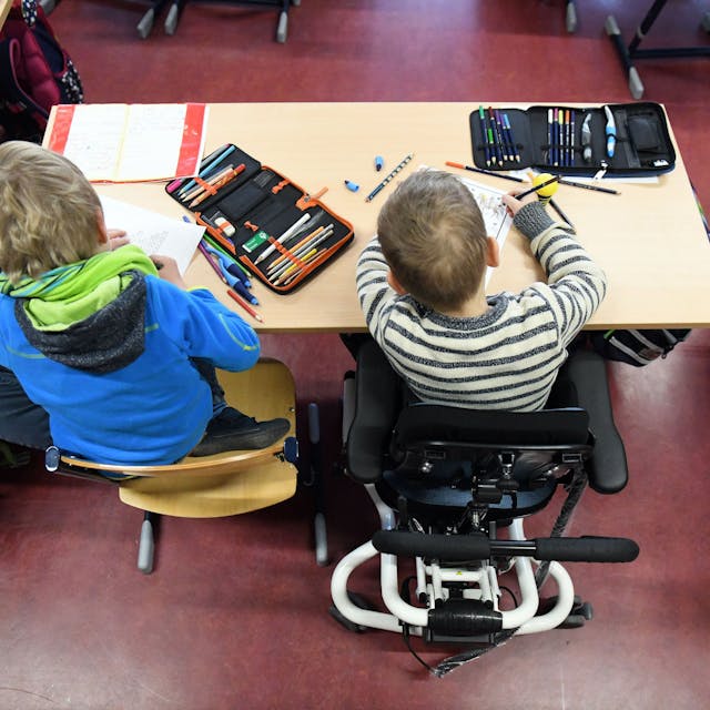Ein Kind mit Behinderung sitzt in seinem Rollstuhl in einer Klasse.&nbsp;