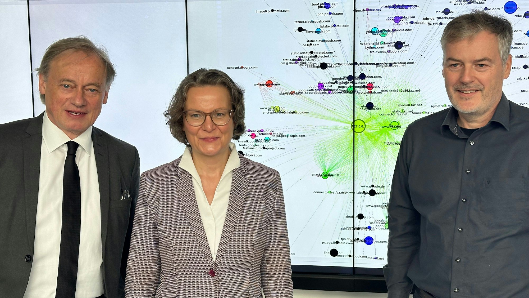 Gruppenfoto mit Ministerin Ina Scharrenbach, Hochschulpräsident Hartmut Ihne mit dunkler Krawatte und Professor André Hinkenjann, der keine Krawatte trägt.