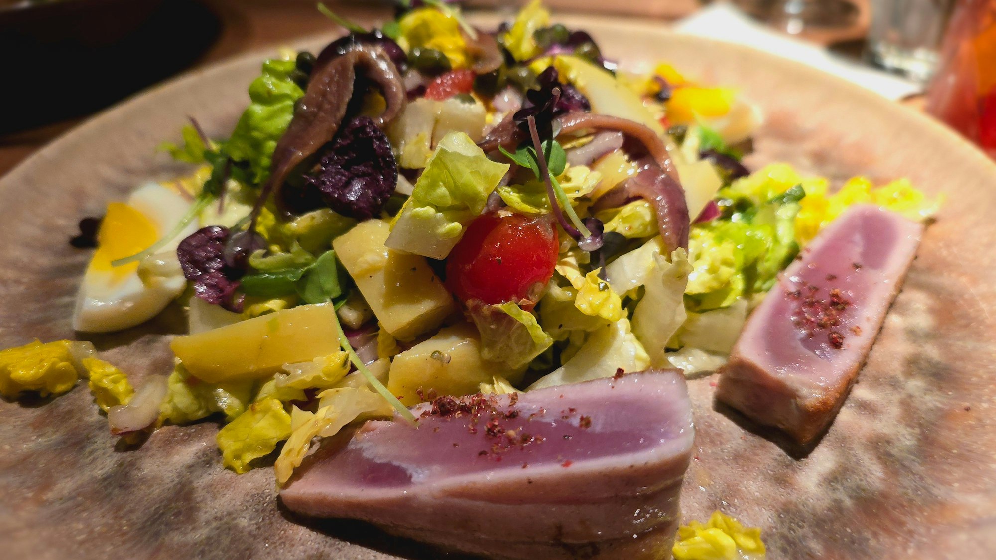 Salade niçoise mit Thunfisch angerichtet auf einem Teller
