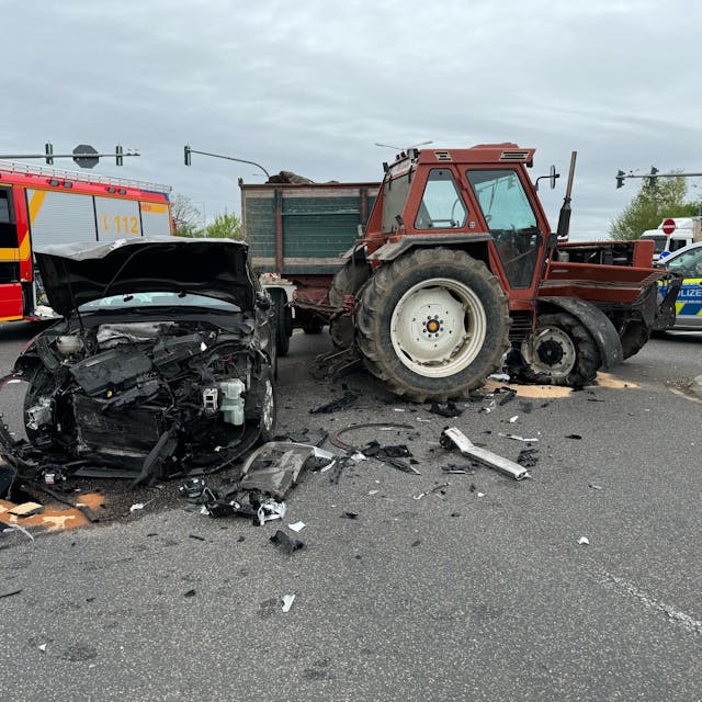 Das Bild zeigt einen beschädigten Pkw und einen beschädigten Traktor