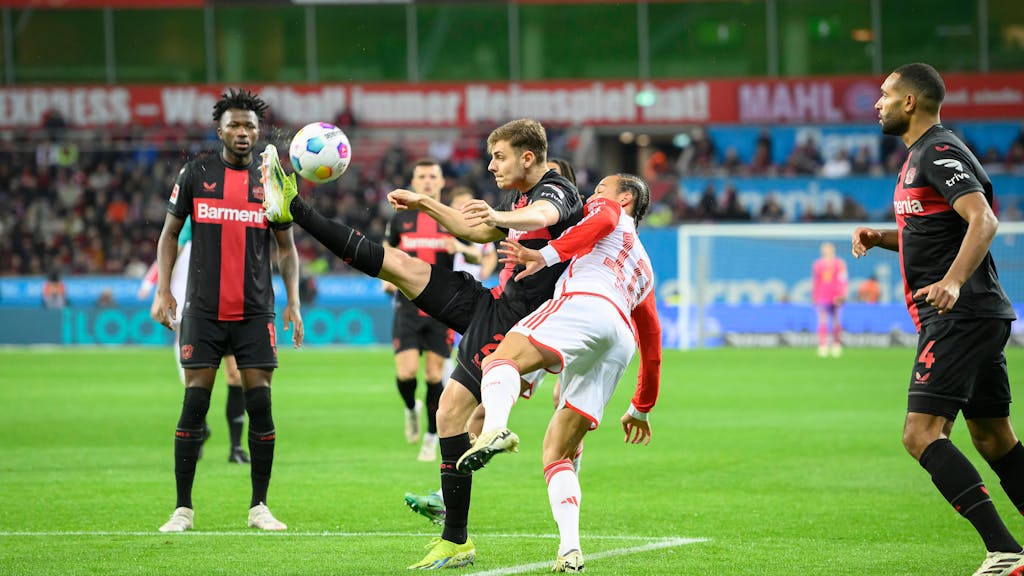 Josip Stanisic (Leverkusen) in einem Zweikampf mit Leroy Sané (FC Bayern München).