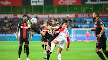 Josip Stanisic (Leverkusen) in einem Zweikampf mit Leroy Sané (FC Bayern München).