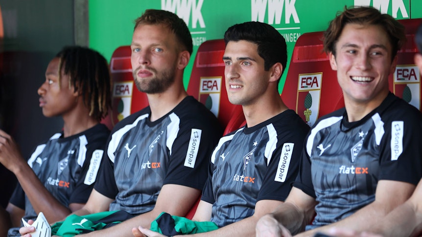 Vier Borussia-Spieler sitzen auf der Augsburger Auswechselbank.