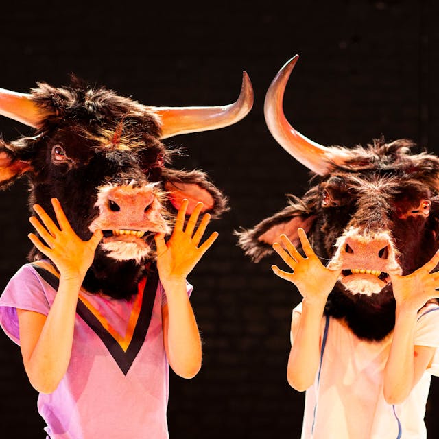 Zwei Tänzerinnen tragen lebensechte Auerochsenmasken.