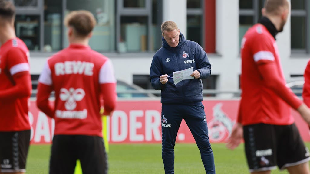 Training beim 1. FC Köln: Timo Schultz notiert mit einem Kugelschreiber etwas auf einem Zettel.