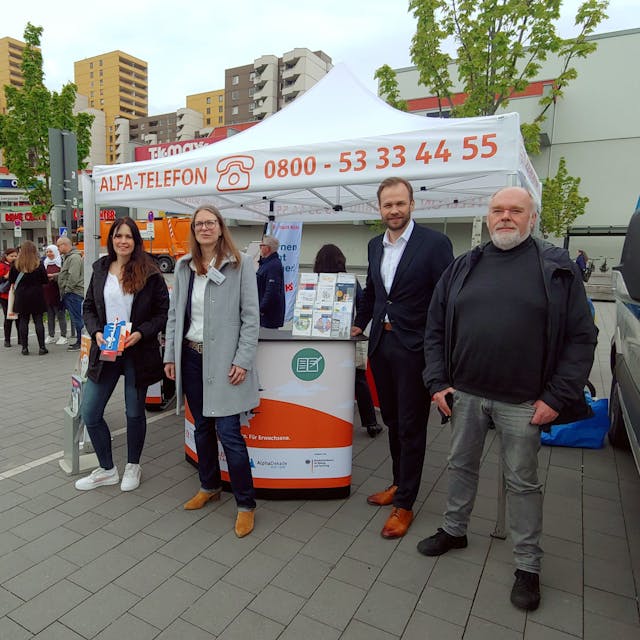 Am „ALFA-Mobil“ kommen auf dem Liverpooler Platz am Donnerstag (v. l.) Juliane Averdung, Anja Kischel sowie Kai Sterzenbach und Robert Voigtsberger ins Gespräch mit Menschen in Chorweiler.