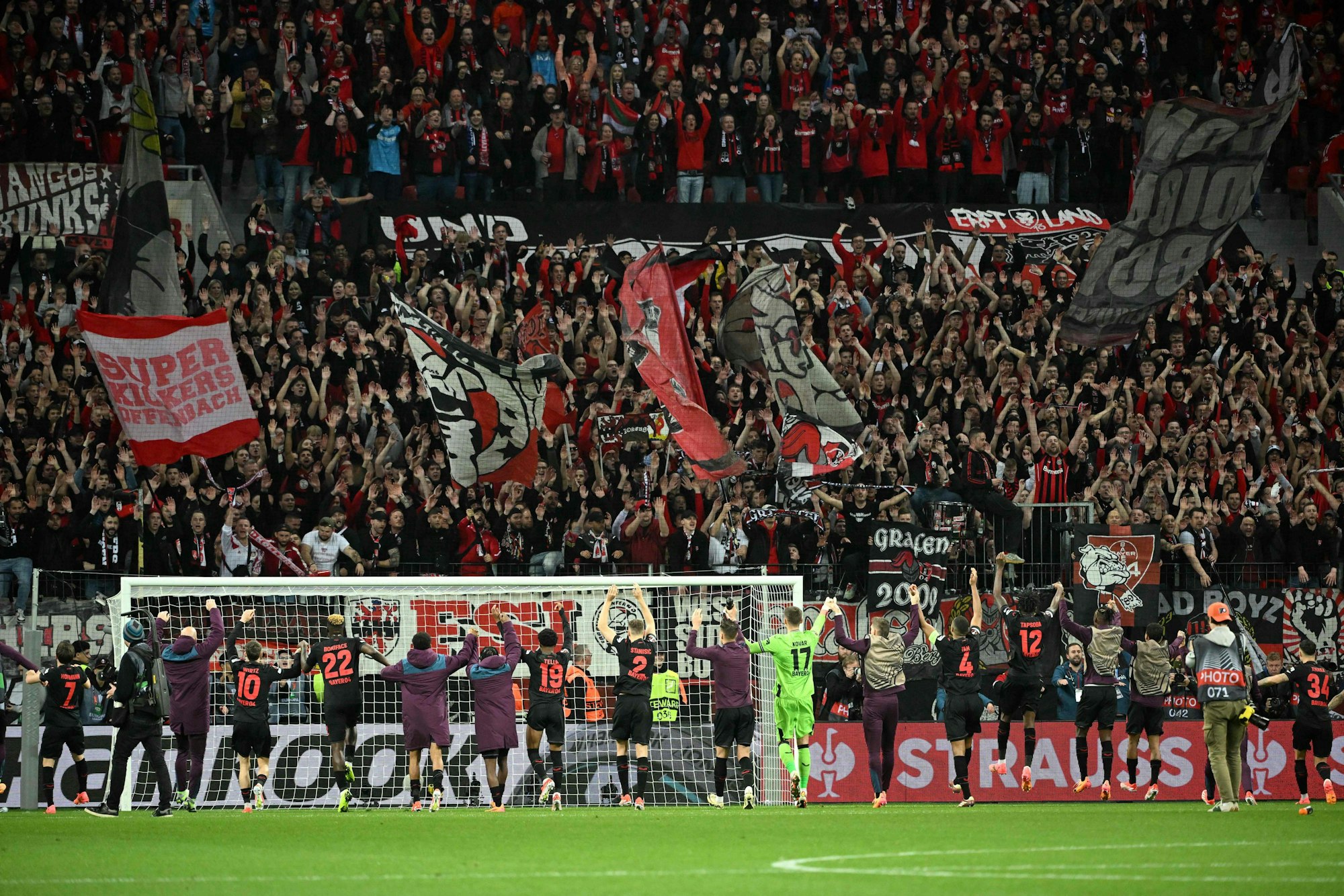 Bayer Leverkusen's players celebrate with fans at the end of the UEFA Europa League quarter-final first leg football match between Bayer 04 Leverkusen and West Ham United FC in Leverkusen, western Germany on April 11, 2024. Bayer Leverkusen won the match 2-0. (Photo by INA FASSBENDER / AFP)
