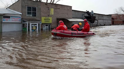 Russian Emergency Ministry employees ride a boat as they patrol the flooded street in Orenburg, Russia, Friday, April 12, 2024. Floods have sparked evacuations of thousands in the Orenburg region, located some 1,200 kilometers (745 miles), southeast of the capital of Moscow after a dam on the river burst last week under the pressure of surging waters. Local authorities have declared a state of emergency in the region. (AP Photo)