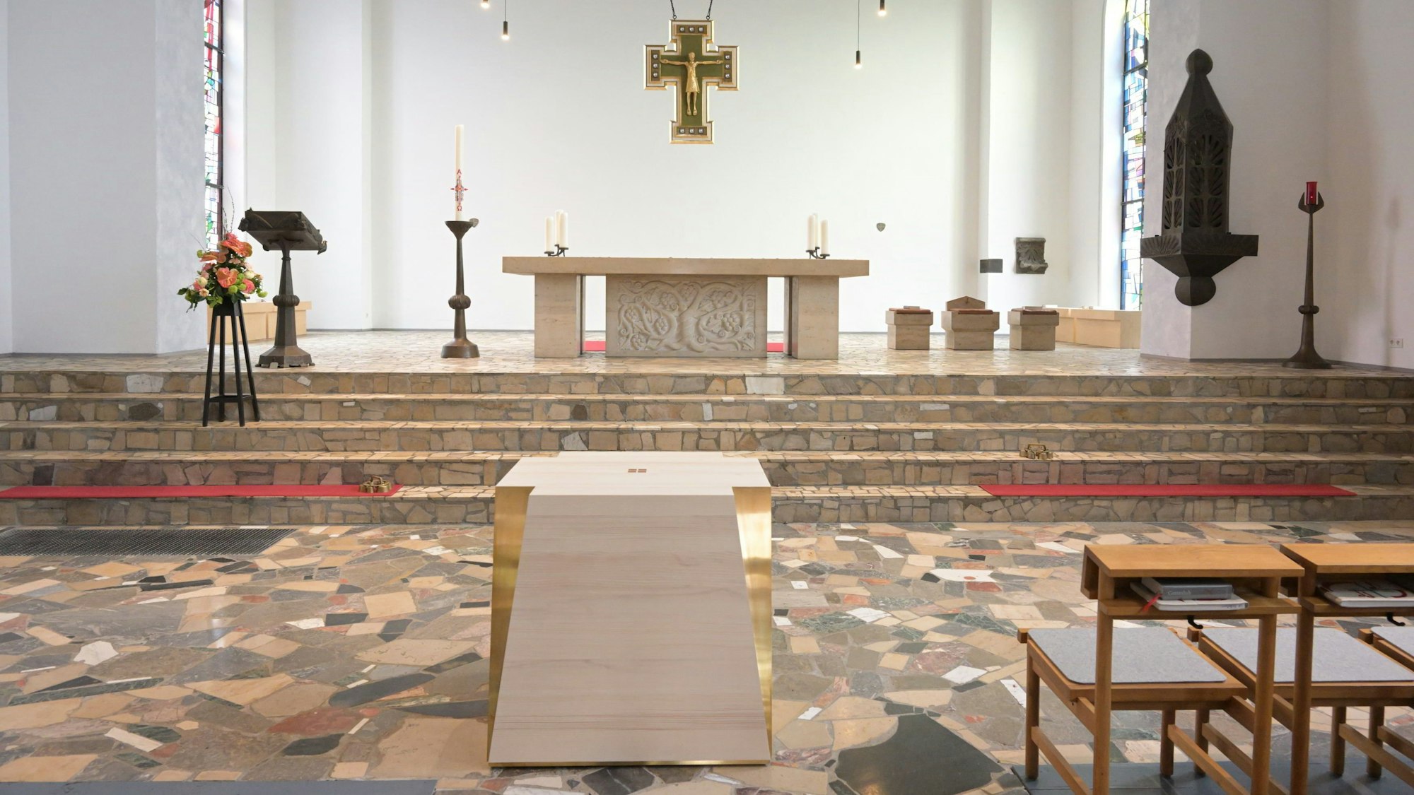 Ein großer Steinaltar in einer Kirche, unterhalb der mobile Nebenaltar aus Holz und Messing.