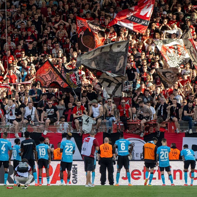 Die Spieler von Bayer Leverkusen vor ihren jubelnden Fans.