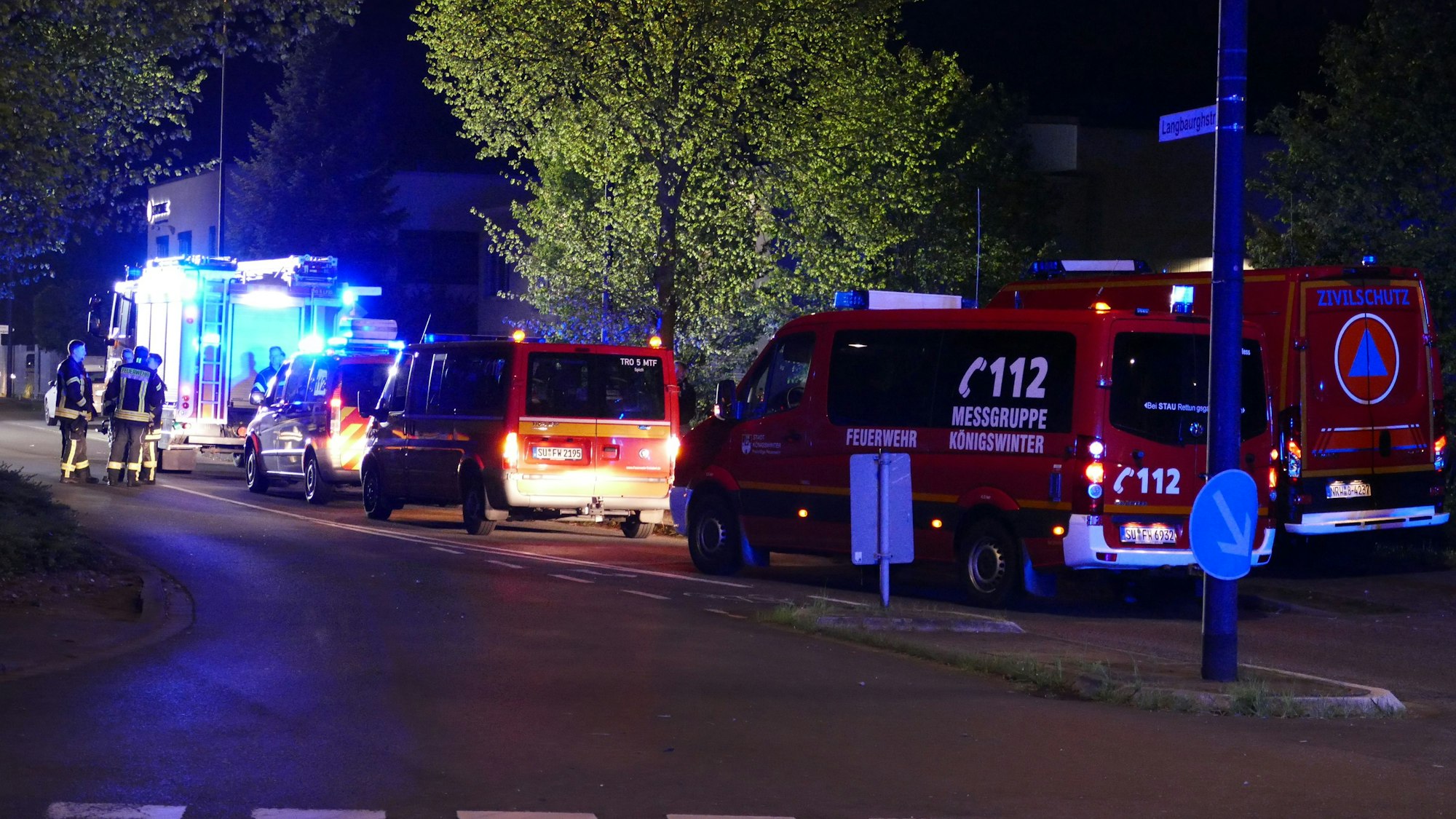 Mehrere Einsatzfahrzeuge der Feuerwehr stehen in der Nacht auf einer Straße.