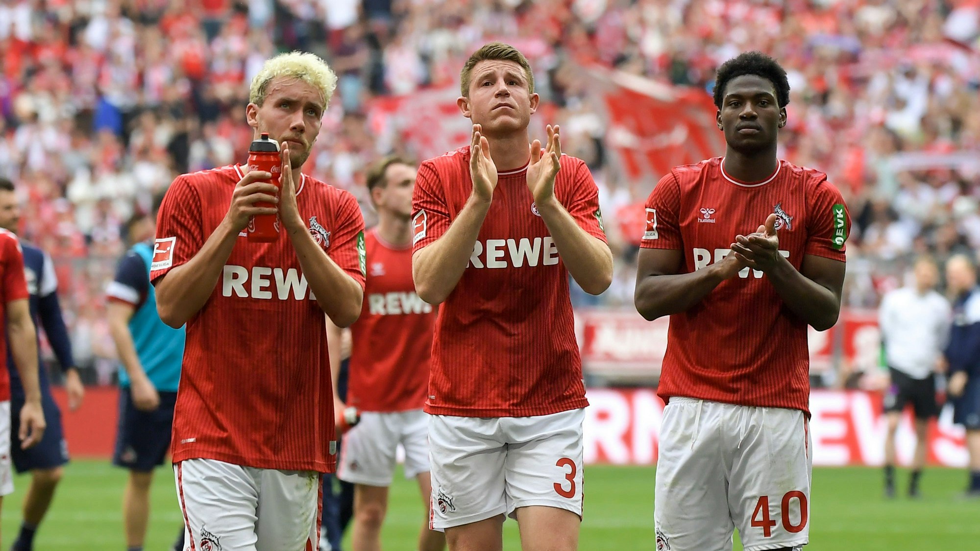 Luca Waldschmidt (l.), Dominique Heintz (Mitte) und Faride Alidou bedanken sich am Samstag (13. April 2024) bei den nach München mitgereisten FC-Fans.