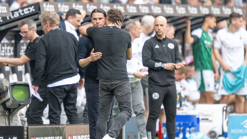 Trainer von Borussia Mönchengladbach und Trainer von Borussia Dortmund ligen sich in den Armen.