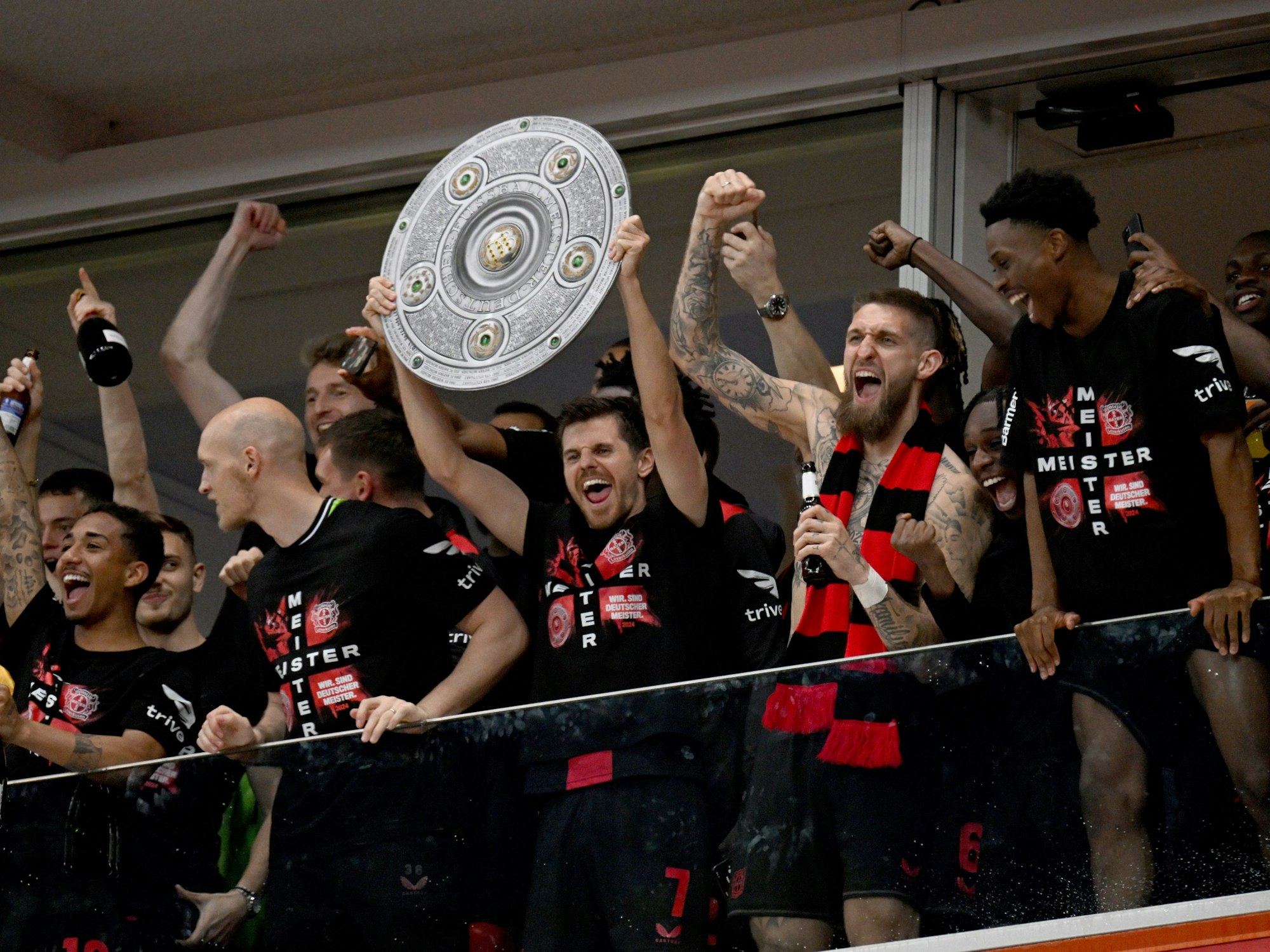 Die Leverkusener Mannschaft ließ sich dann auf der Tribüne blicken, brachte eine Meisterschale aus Pappe mit und feierte mit den Fans, die im Stadion-Innenraum gewartet hatten.