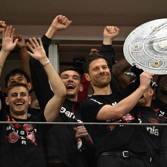 Bayer Leverkusen's Spanish head coach Xabi Alonso celebrates with a mock-up of the Bundesliga trophy with his players after the German first division Bundesliga football match Bayer 04 Leverkusen v Werder Bremen in Leverkusen, western Germany, on April 14, 2024. Bayer Leverkusen were crowned 2023-24 Bundesliga champions for the first time on April 14, 2024.  (Photo by INA FASSBENDER / AFP) / DFL REGULATIONS PROHIBIT ANY USE OF PHOTOGRAPHS AS IMAGE SEQUENCES AND/OR QUASI-VIDEO