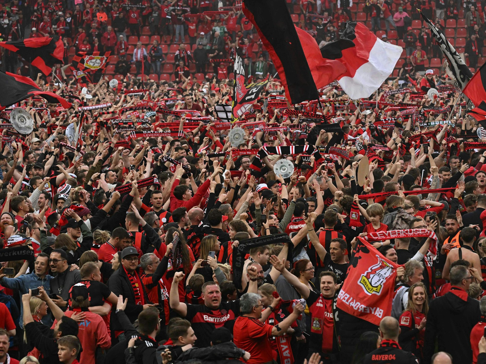 Die Leverkusener Fans feiern auf dem Platz den ersten Meister-Titel der Vereins-Geschichte.