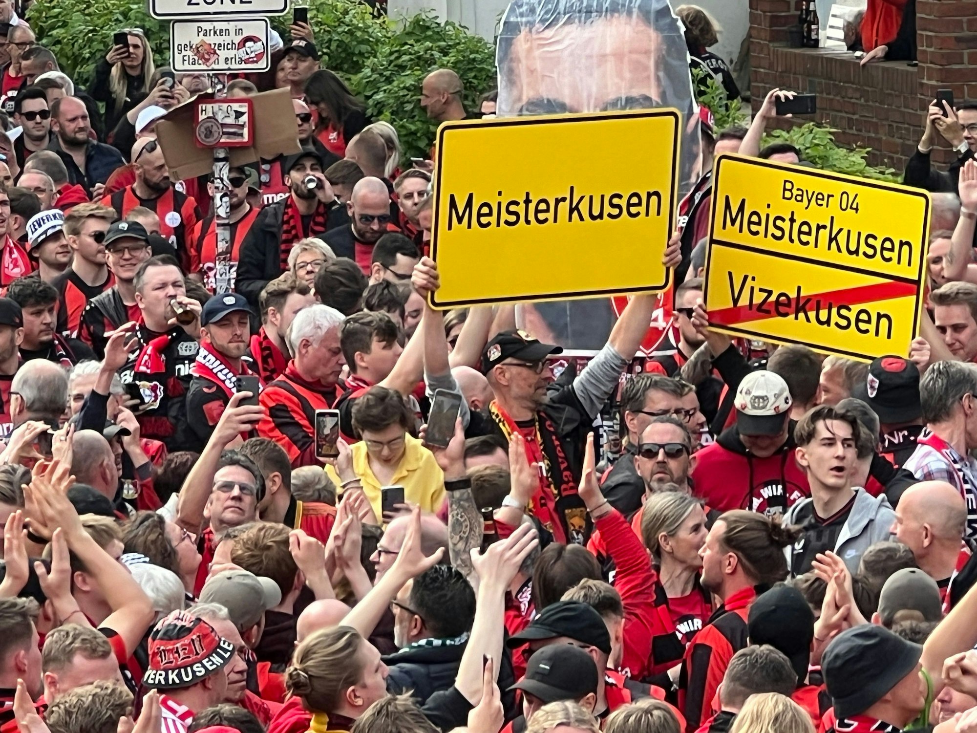 Lauter Fans mit Schildern „Meisterkusen“ oben und „Vizekusen“ durchgestrichen unten.