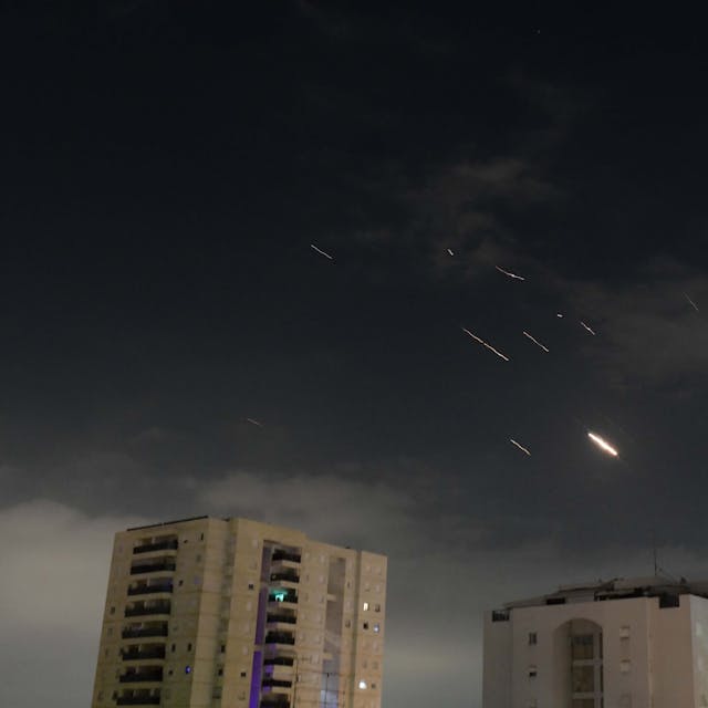 Flammen von Explosionen erscheinen am Himmel über Tel Aviv, während Israels Raketenabwehrsystem Raketen und Drohnen aus dem Iran abfängt.