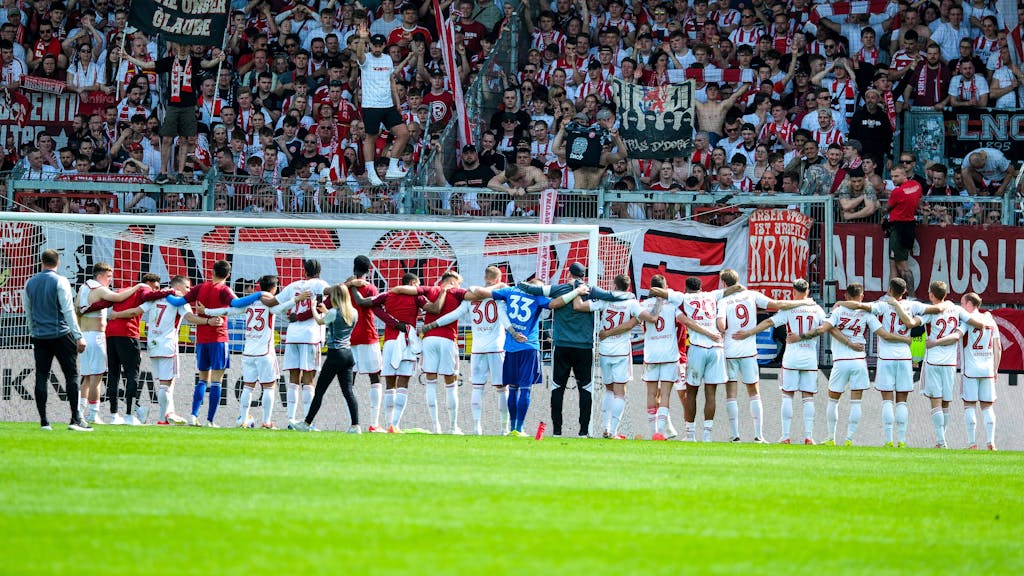 Die Mannschaft von Fortuna Düsseldorf steht nach dem Sieg in Wiesbaden vor den mitgereisten Fans.