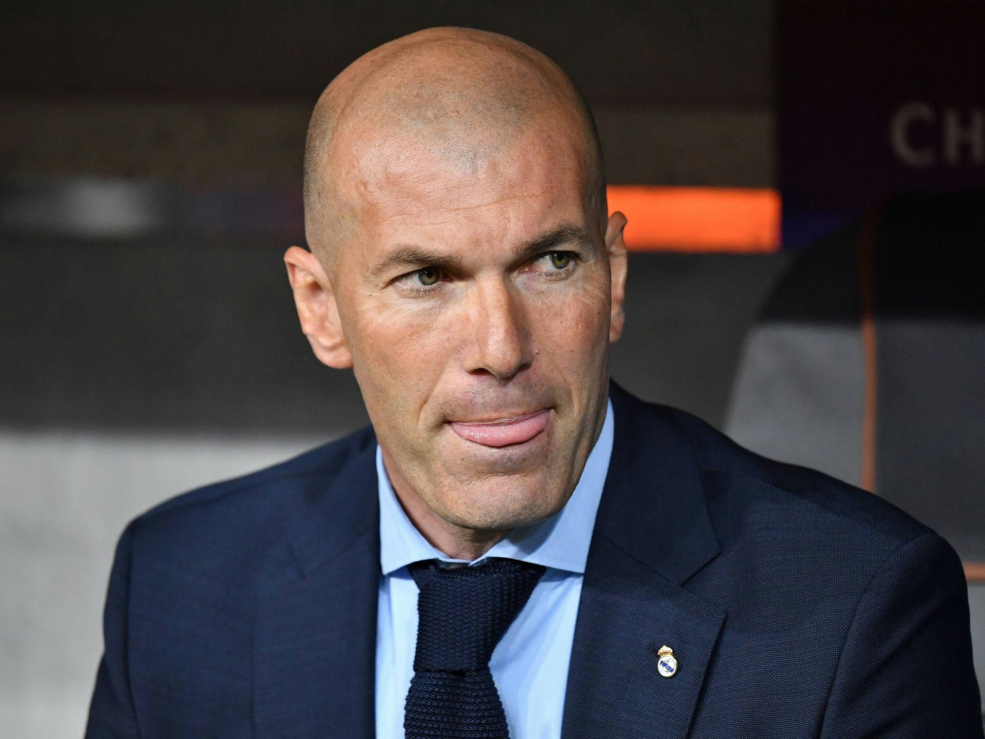 Zinédine Zidane sitzt auf er Trainerbank im Stadion.