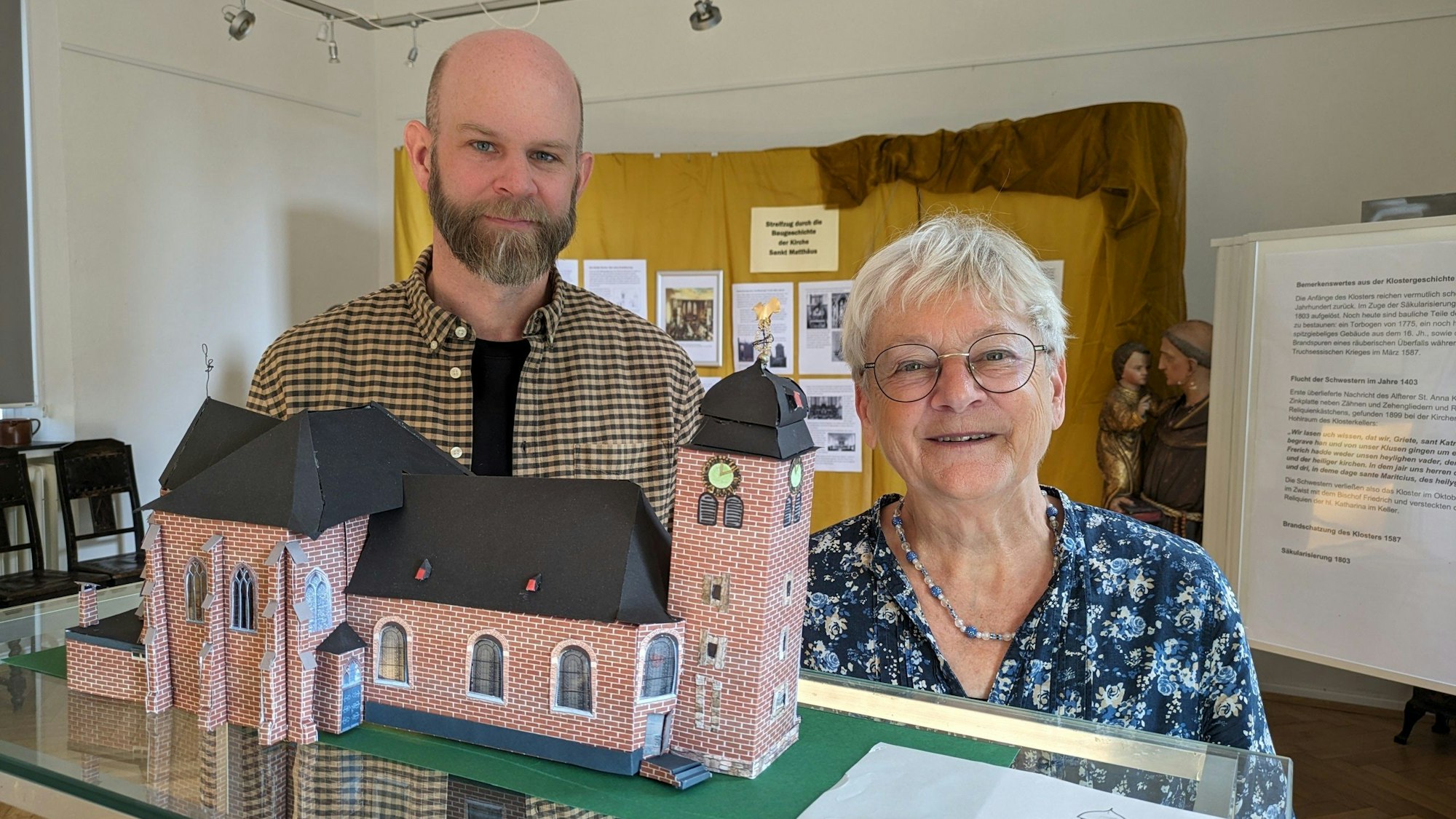 Bärbel Steinkemper und Robin Huth vor dem Modell der Pfarrkirche St. Matthäus im heutigen Zustand.