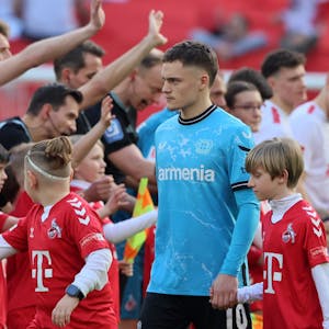 Florian Wirtz von Bayer 04 Leverkusen klatscht im Spiel bei seinem Ex-KLub 1. FC Köln mit den Ballkindern ab.
