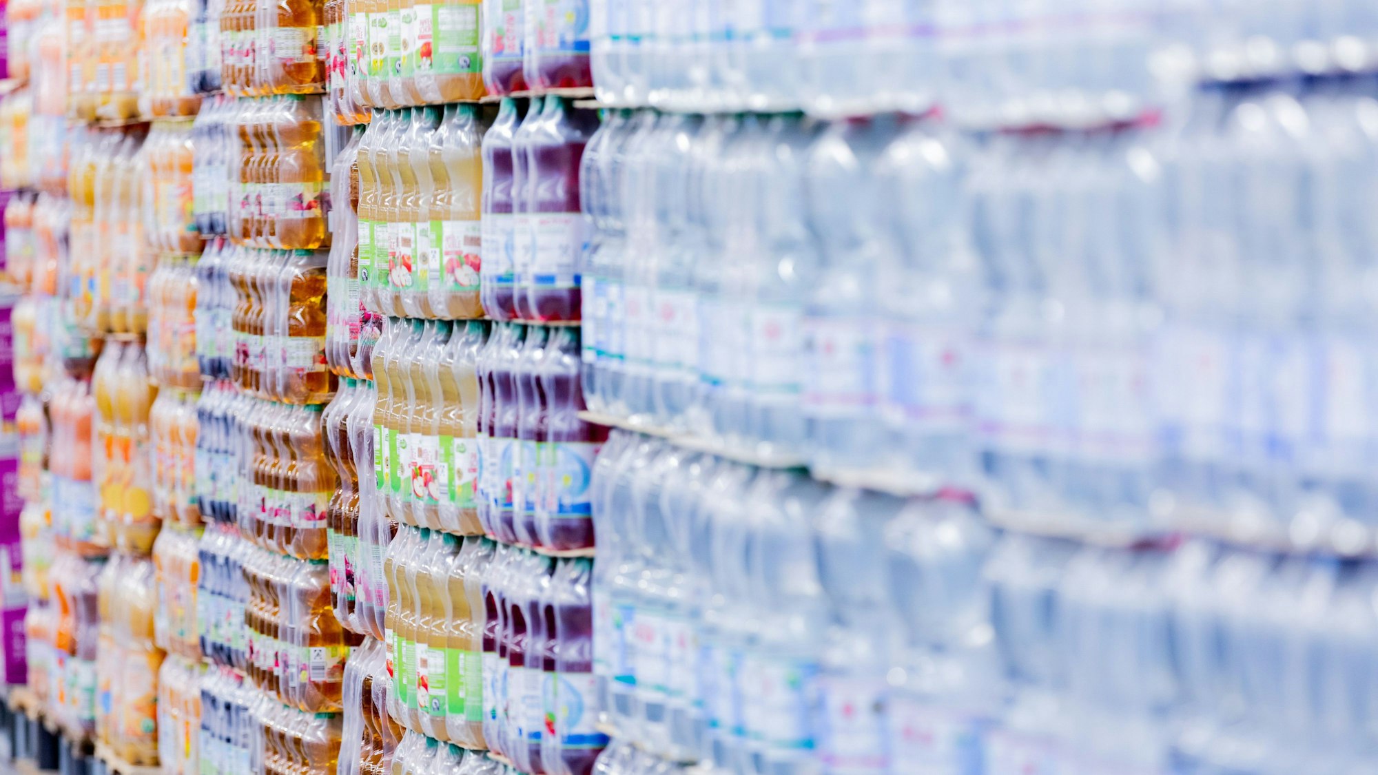 Einweg-Plastikflaschen stehen in einem Supermarkt auf Paletten.