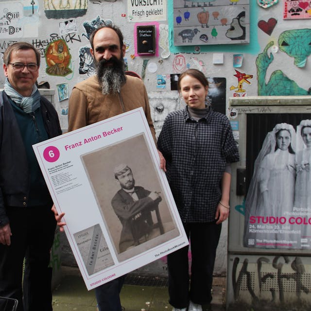 Markus Schaden, Frederic Lezmi und Leonie Serbo (v. l.) halten ein Porträt von Franz Anton Becker aus einem Kölner Photoatelier des 19. und 20. Jahrhunderts.