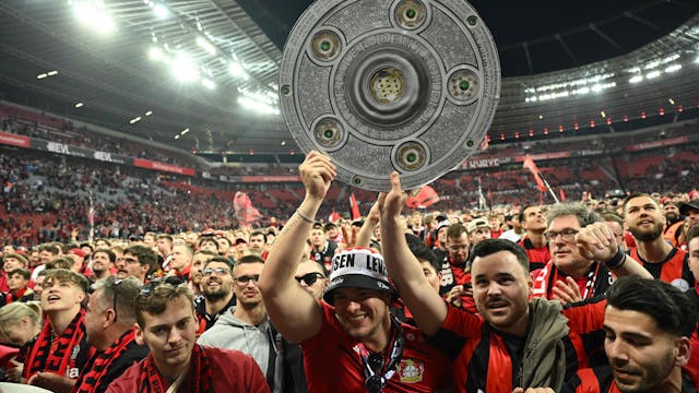 Bayer Leverkusen Fans mit Meisterschale auf dem Stadionrasen