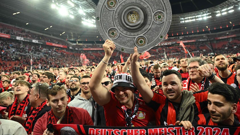 Bayer Leverkusen Fans mit Meisterschale auf dem Stadionrasen